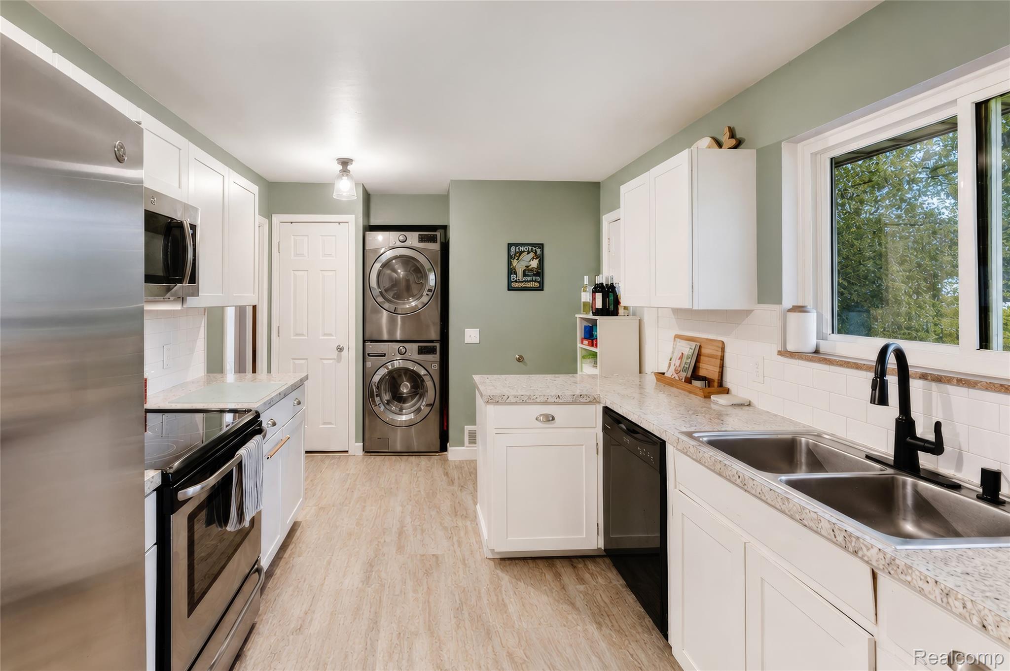 4499 South Linden Road Flint, MI 48507 - Photo 13 of 36 Kitchen featuring white cabinetry, light-toned countertops, stainless steel appliances, and wood-finish flooring