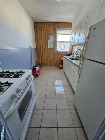 a kitchen with granite countertop a stove a sink dishwasher and a refrigerator