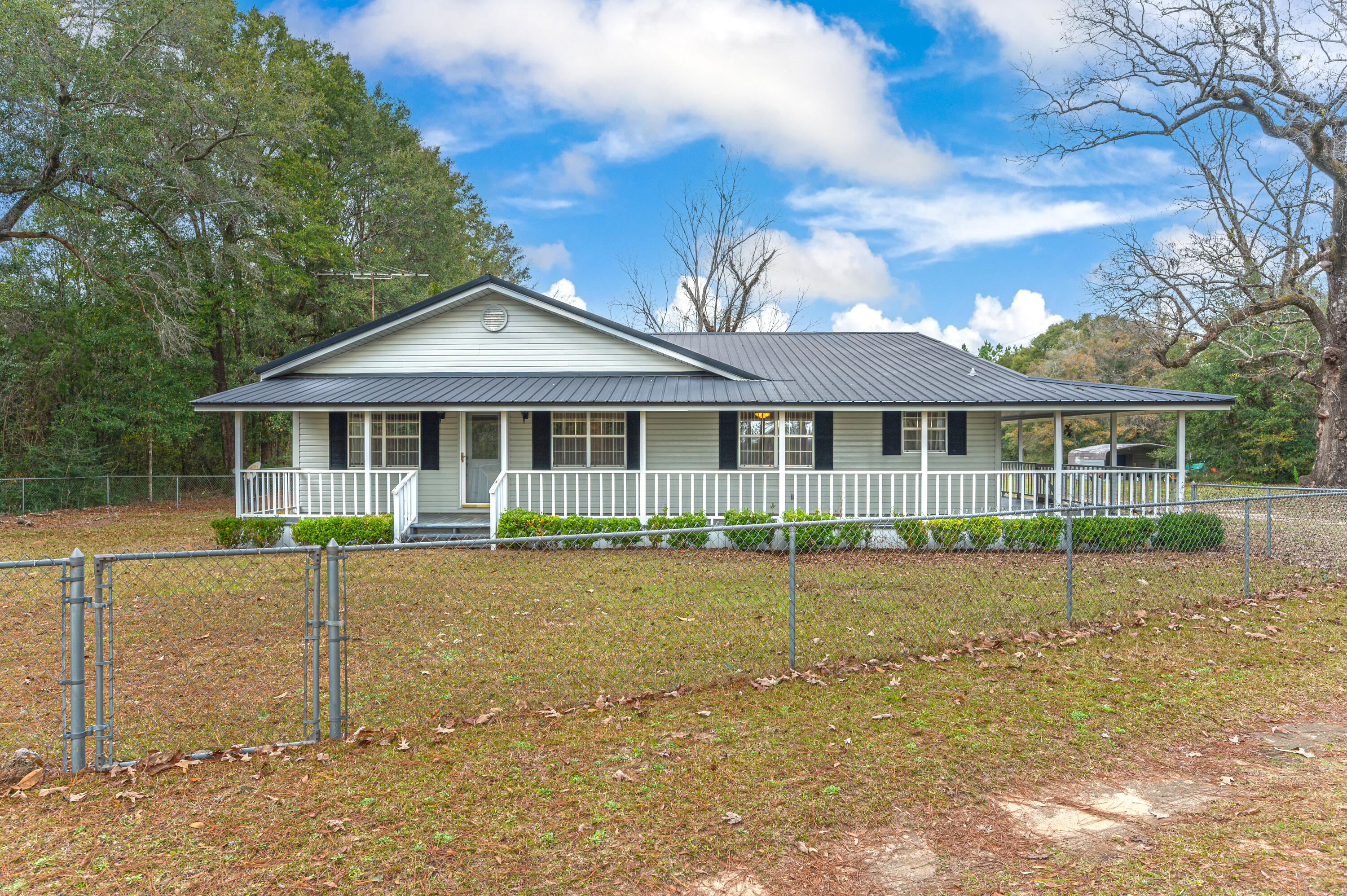 6433 Old River Road Baker, FL 32531 - Photo 1 of 27 a front view of a house with a garden