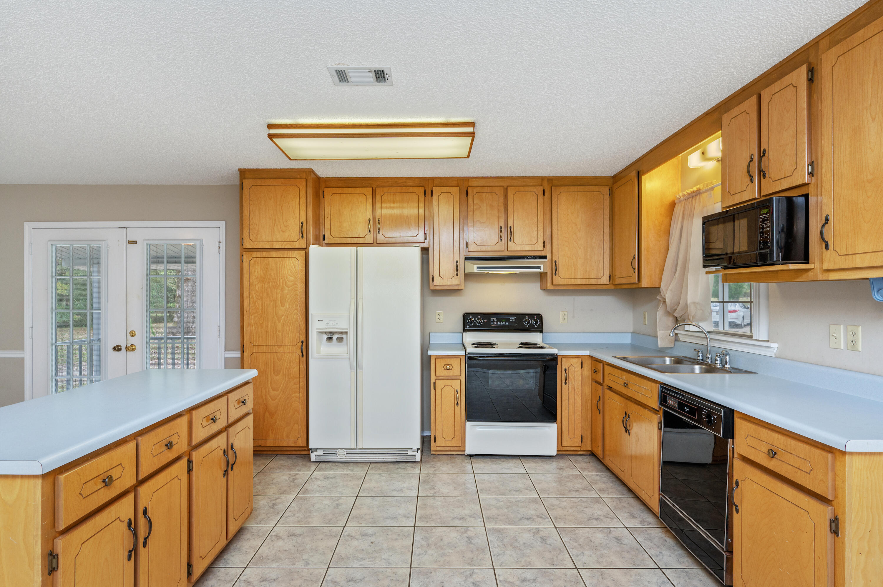 6433 Old River Road Baker, FL 32531 - Photo 10 of 27 a kitchen with stainless steel appliances granite countertop a stove a sink dishwasher a refrigerator and a microwave