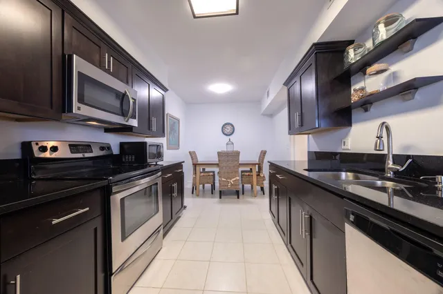 a kitchen with stainless steel appliances granite countertop a sink stove and cabinets