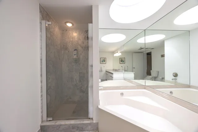 a bathroom with a tub a sink and a mirror