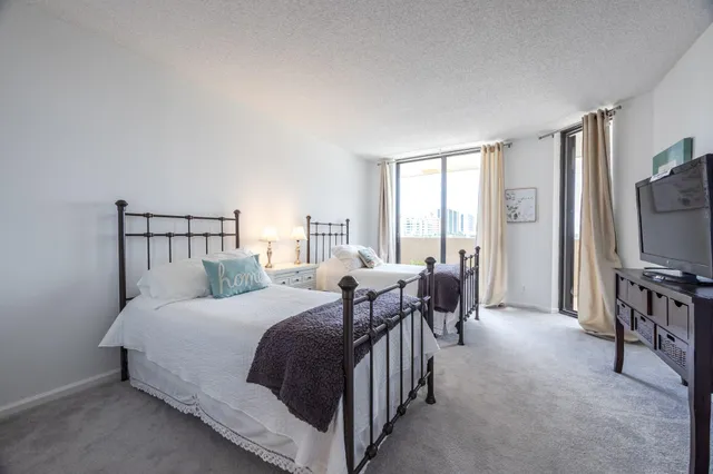 a bedroom with a bed a flat screen tv and a couch