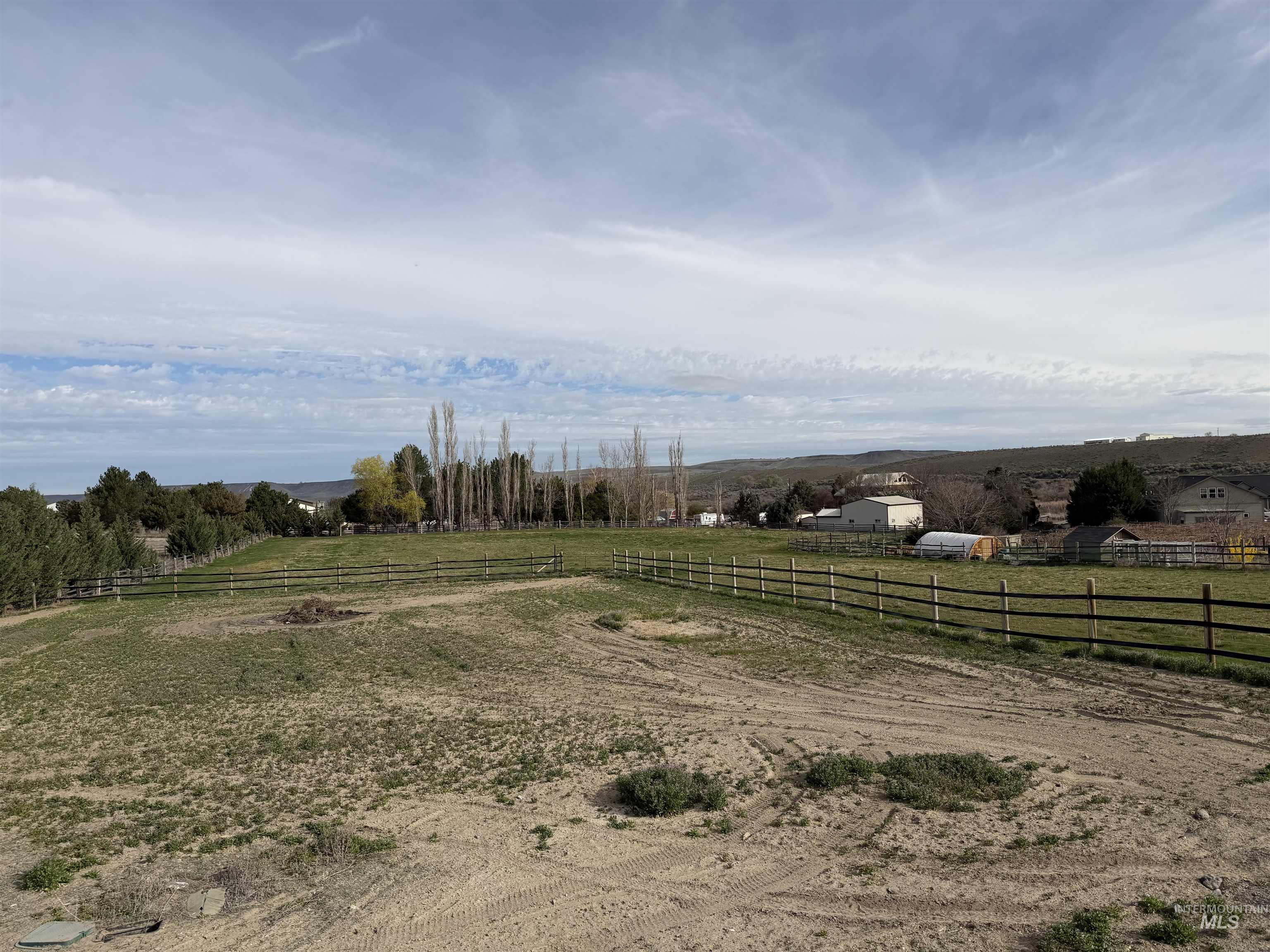 View of yard with an outdoor riding arena and a rural view