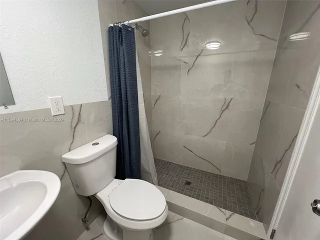a white toilet sitting next to a bath tub