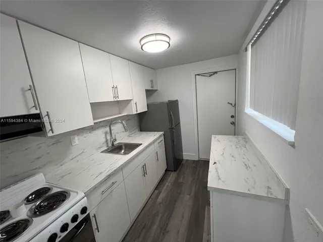 a kitchen with a sink stove and refrigerator