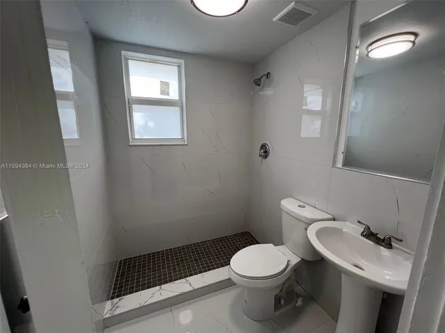 a white toilet sitting next to a bathroom sink