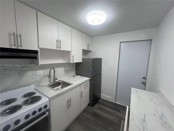 a kitchen with a sink stove and cabinets