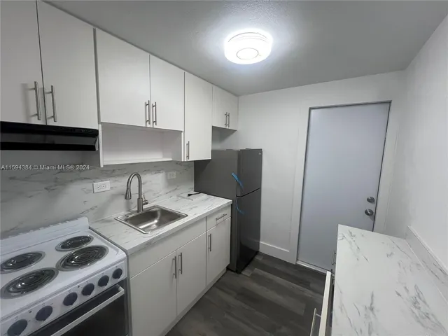 a kitchen with a sink stove and cabinets