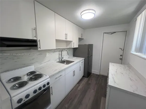 a kitchen with a stove a sink and a refrigerator