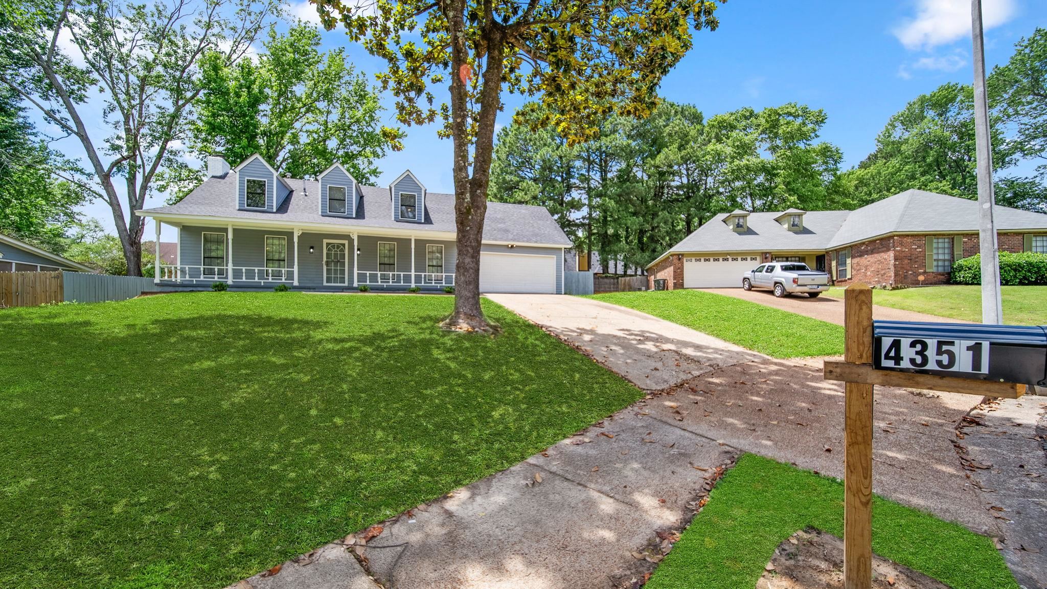 4351 Spring Oak Cove Memphis, TN 38125 - Photo 2 of 40 a front view of a house with a yard and trees