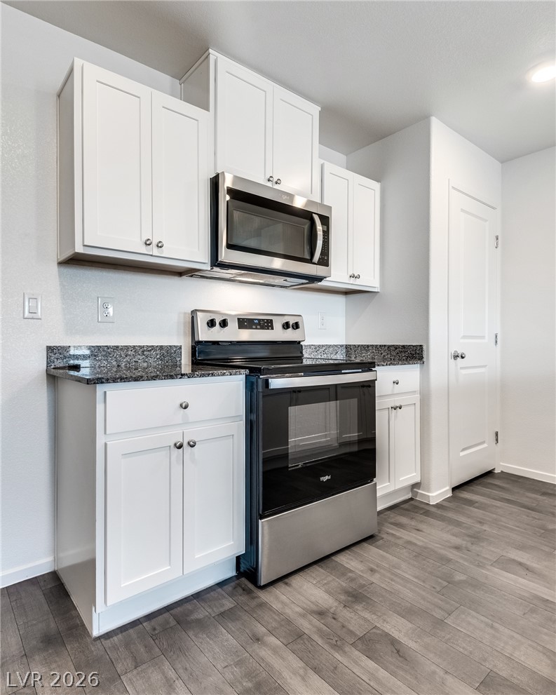 1114 Scarlet Sparrow Street Henderson, NV 89011 - Photo 11 of 25 Modern kitchen with granite counters and stainless steel appliances.
