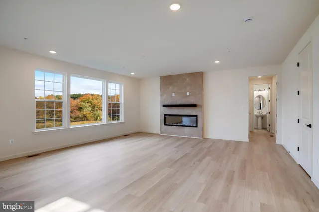 a kitchen with stainless steel appliances granite countertop a sink a stove a refrigerator and white cabinets
