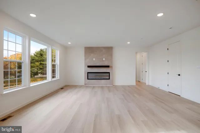 a large white kitchen with wooden floor and a sink