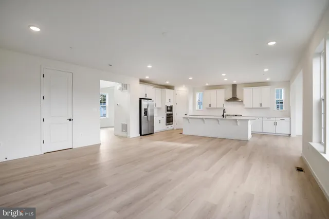 a large white kitchen with white cabinets and stainless steel appliances