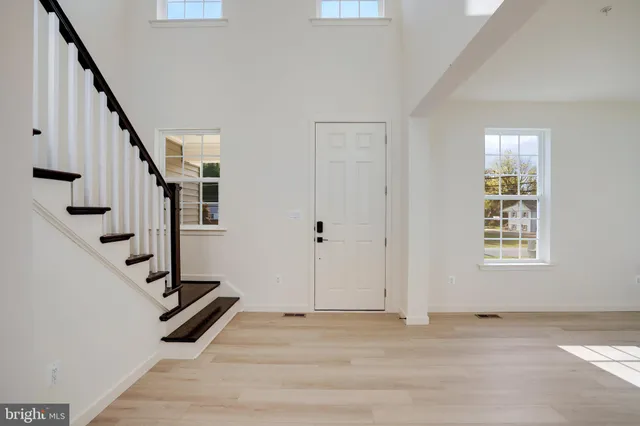 a view of a hallway with wooden floor and a living room