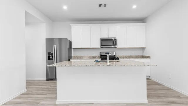 a kitchen with stainless steel appliances a refrigerator sink and stove