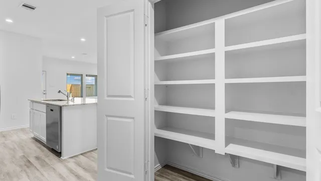 a view of walk in closet with empty racks