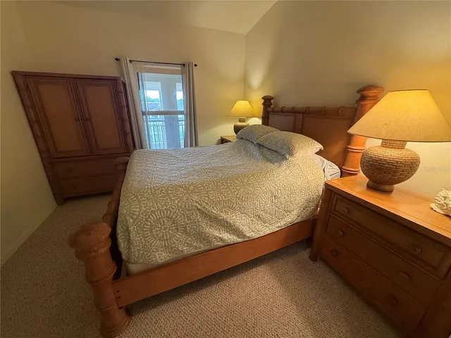 a bed sitting in a bedroom next to a lamp