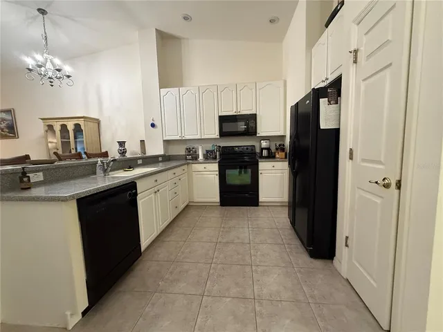 a kitchen with stainless steel appliances granite countertop a refrigerator a sink a stove top oven and a dishwasher