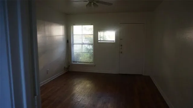 a view of an empty room and wooden floor and windows