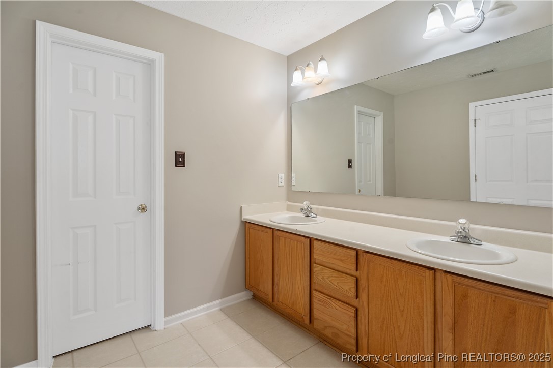 128 Quail Ridge Drive Raeford, NC 28376 - Photo 22 of 50 a bathroom with a double vanity sink and a mirror