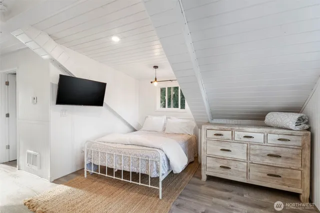 a bedroom with a bed and flat screen tv