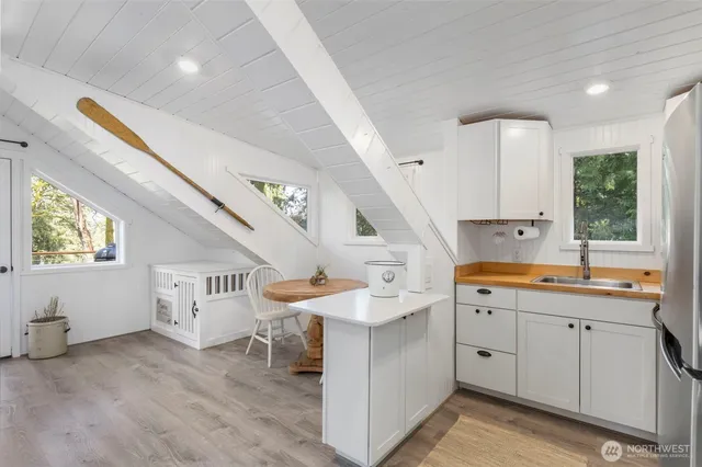 a kitchen with a sink a window and chairs