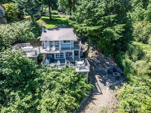 an aerial view of a house with a yard and large trees