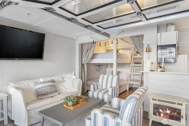 a living room with furniture a flat screen tv and a floor to ceiling window
