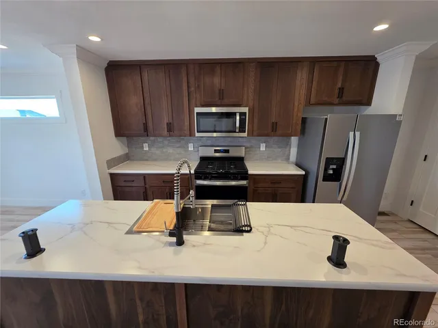 a kitchen with a sink a stove and refrigerator