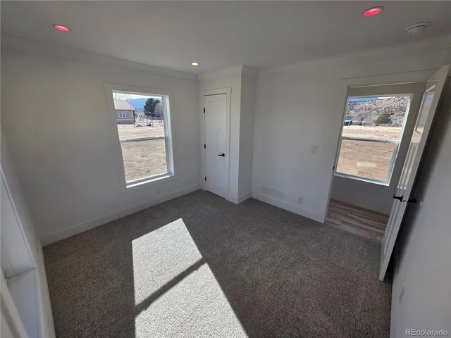 an empty room with windows and fan