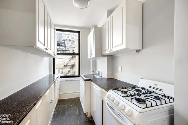a kitchen with a stove a sink and a window