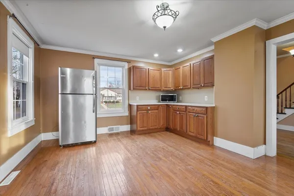 a kitchen with stainless steel appliances granite countertop a refrigerator a sink dishwasher a stove and a microwave oven with wooden floor
