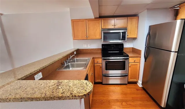 a kitchen with refrigerator granite countertop sink and microwave