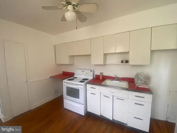 a kitchen with a stove cabinets and wooden floor