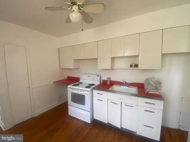 a kitchen with a stove cabinets and wooden floor