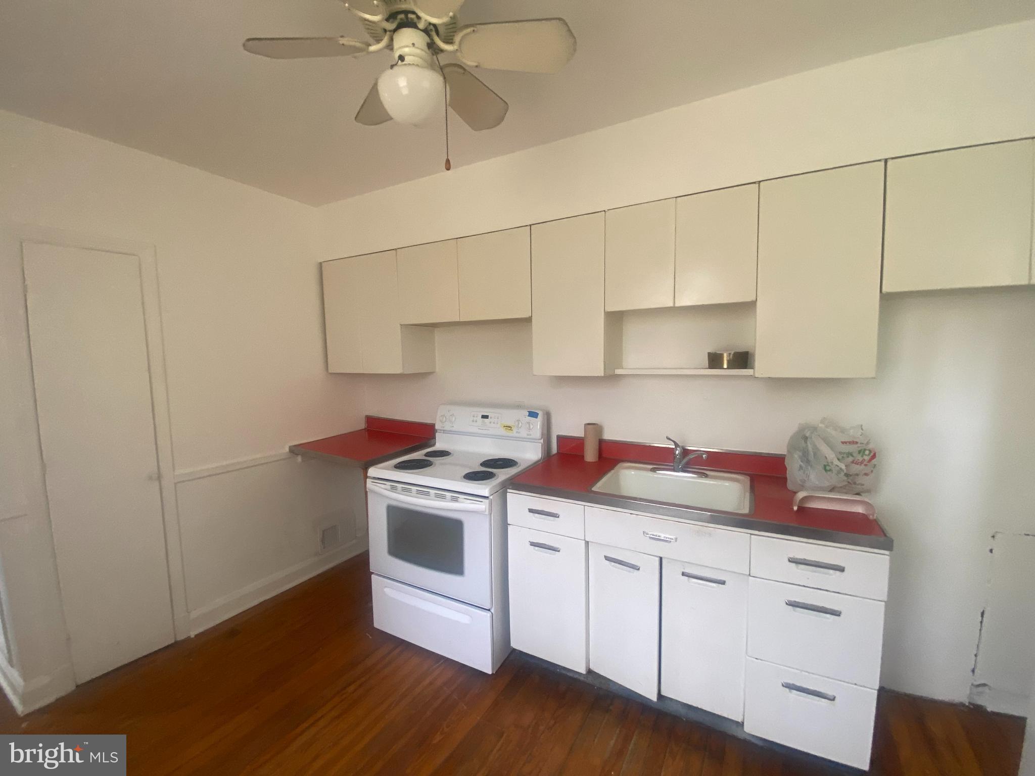 3305 Rosekemp Avenue Baltimore, MD 21214 - Photo 5 of 5 a kitchen with a stove cabinets and wooden floor