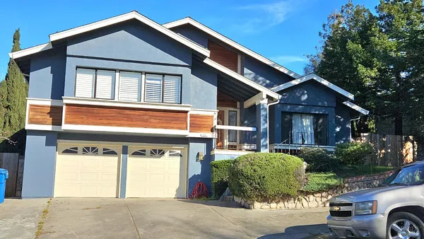 a front view of a house with a garden and plants