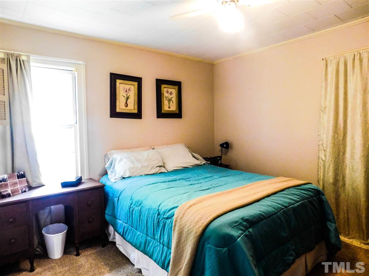 1096 Gillis Road Roxboro, NC 27574 - Photo 9 of 16 a bedroom with a bed and a mirror