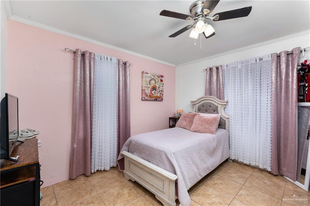 118 J R Becerra Avenue Progreso, TX 78596 - Photo 6 of 17 a bedroom with a bed and a flat tv screen