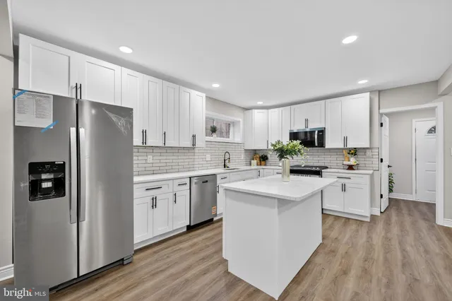 a kitchen with white cabinets and white stainless steel appliances