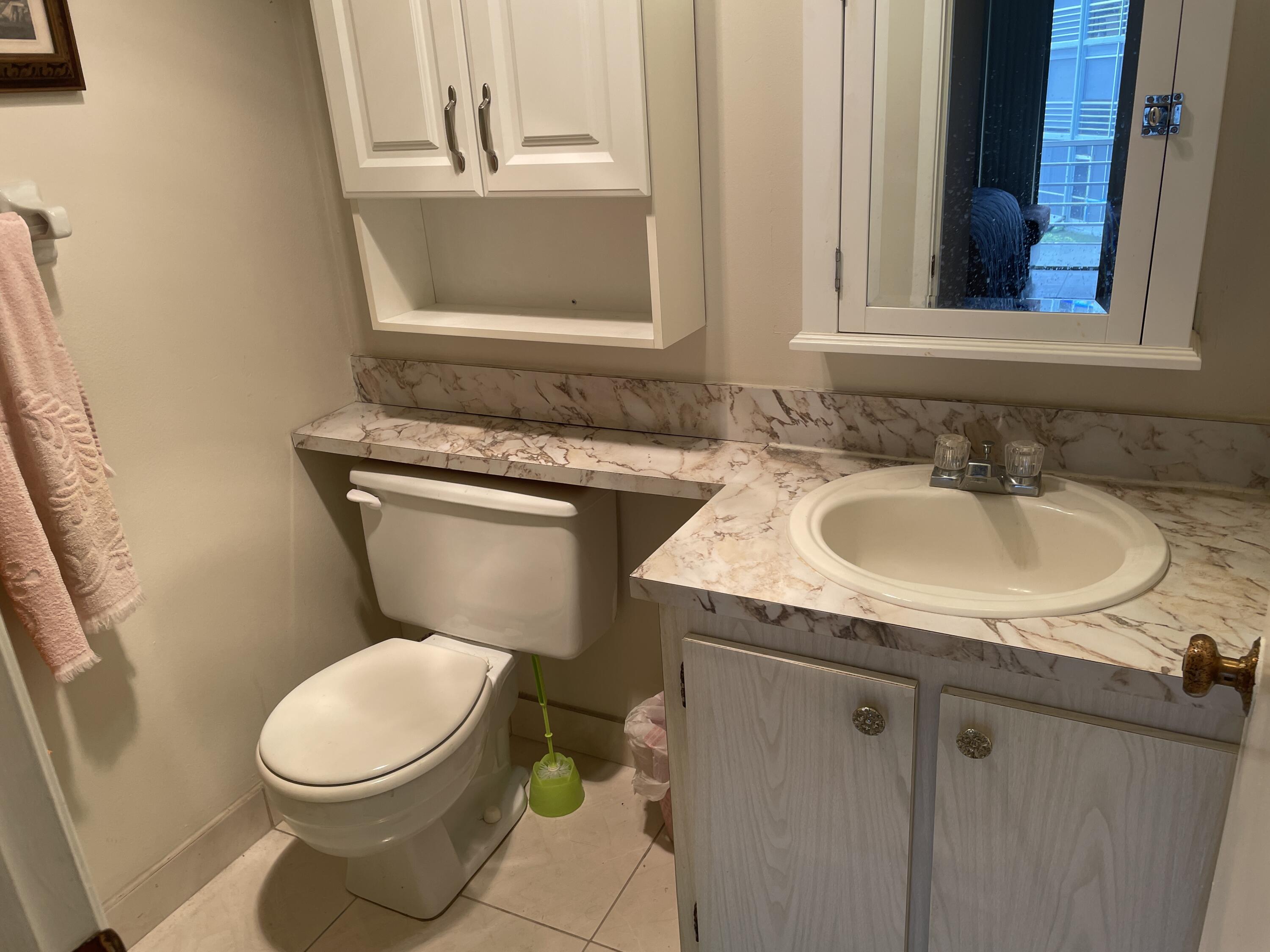 3300 Springdale Boulevard, Unit 201 Palm Springs, FL 33461 - Photo 42 of 49 a bathroom with a granite countertop toilet sink and mirror