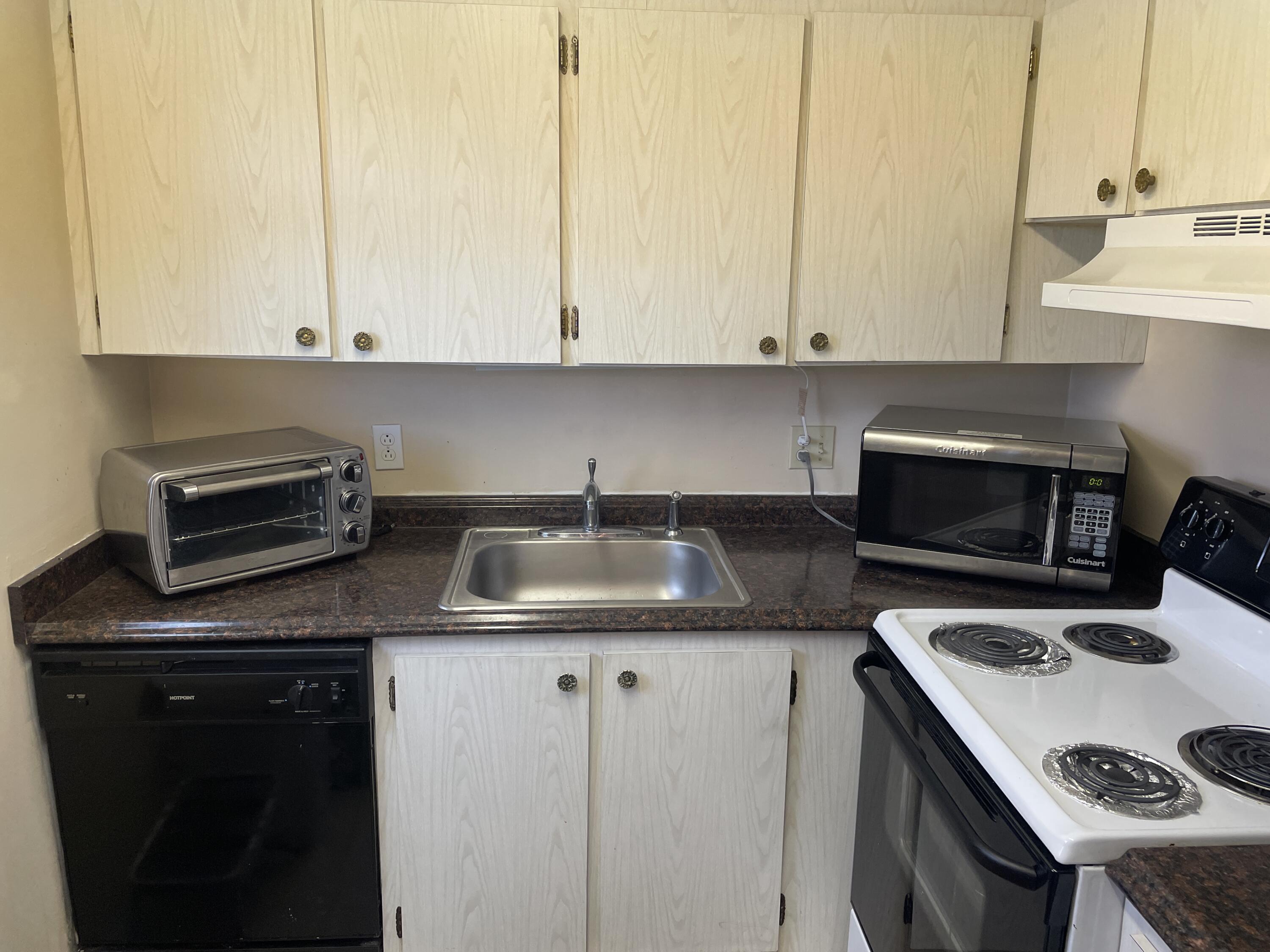 3300 Springdale Boulevard, Unit 201 Palm Springs, FL 33461 - Photo 49 of 49 a kitchen with granite countertop a sink a stove and cabinets