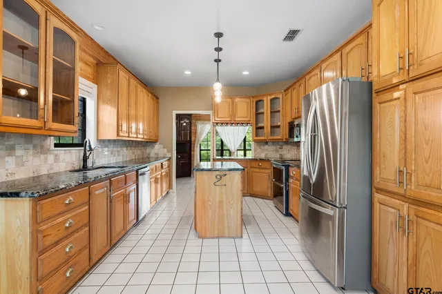 a kitchen with a refrigerator a sink dishwasher with a dining table and chairs