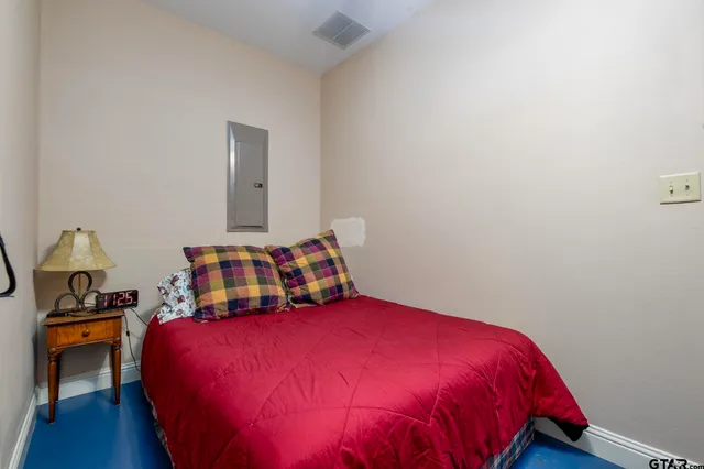 a bedroom with a bed and a lamp on dresser