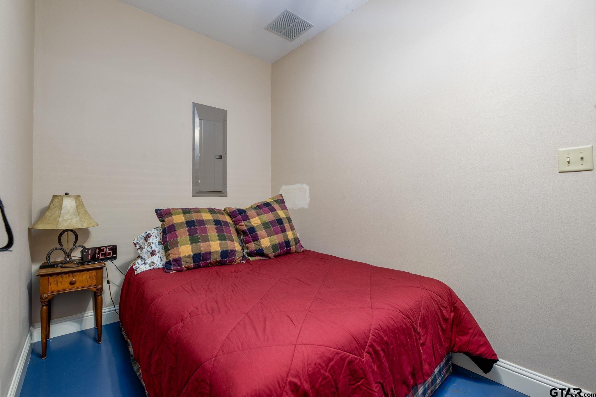 12450 County Road 420 Tyler, TX 75704 - Photo 41 of 48 a bedroom with a bed and a lamp on dresser