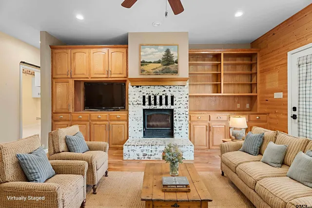 a living room with furniture a fireplace and a flat screen tv
