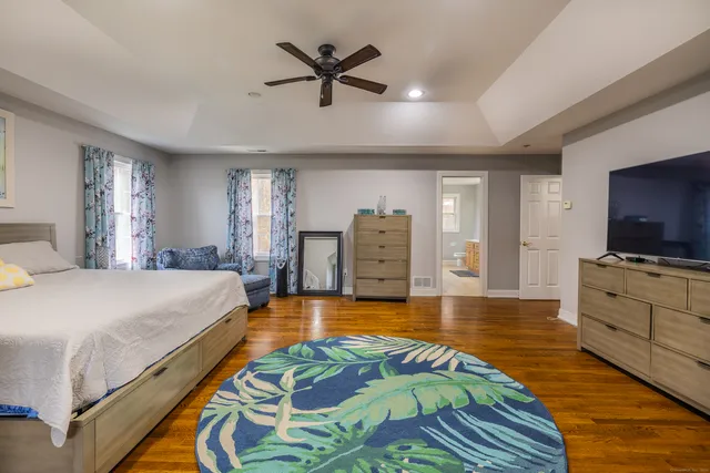 a spacious bedroom with a bed and a flat screen tv