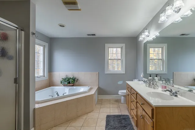 a bathroom with a tub sink and mirror